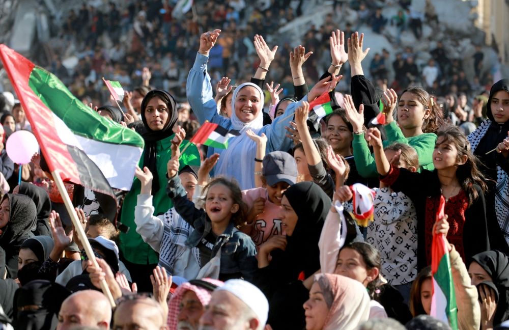 Palestinian women and girls cheer and dance as they gather on the rubble of buildings destroyed during the Gaza War, to watch the mass wedding of 54 couples dubbed the ‘The Dress of Joy’, organised by the Al-Fares Al-Shahm Foundation, in Khan Yunis, southern Gaza Strip on December 2, 2025. — AFP pic Palestinian women and girls cheer and dance as they gather on the rubble of buildings destroyed during the Gaza War, to watch the mass wedding of 54 couples dubbed the ‘The Dress of Joy’, organised by the Al-Fares Al-Shahm Foundation, in Khan Yunis, southern Gaza Strip on December 2, 2025. — AFP pic
