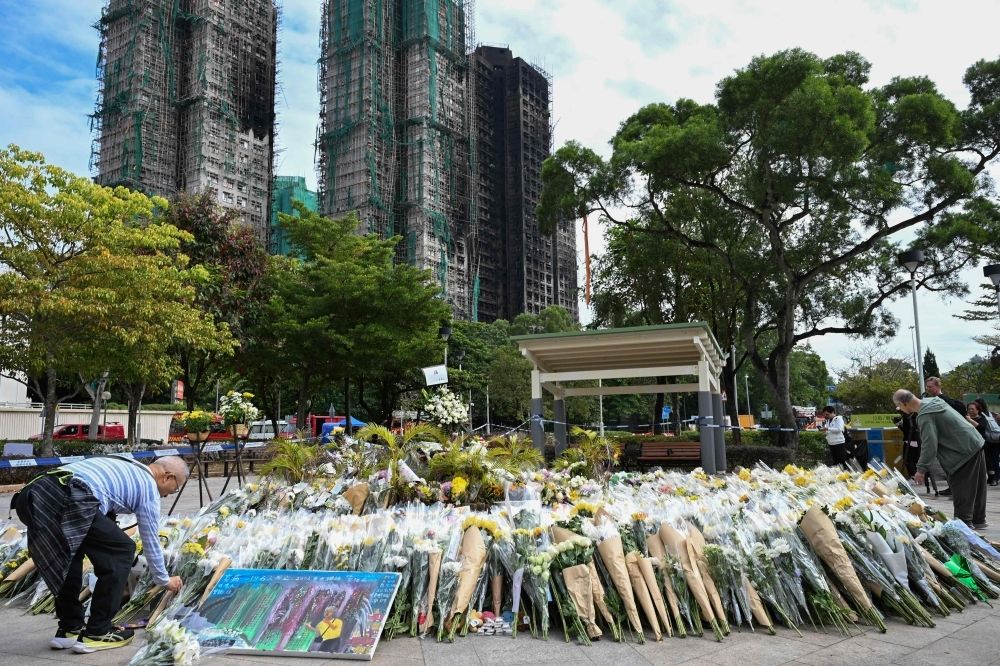 Turnout fears loom as Hong Kong heads to polls amid grief over deadly housing‑block blaze Mourners pay their respects to victims at a makeshift memorial outside the Wang Fuk Court apartment blocks in the aftermath of the deadly November 26 fire in Hong Kong. — AFP pic