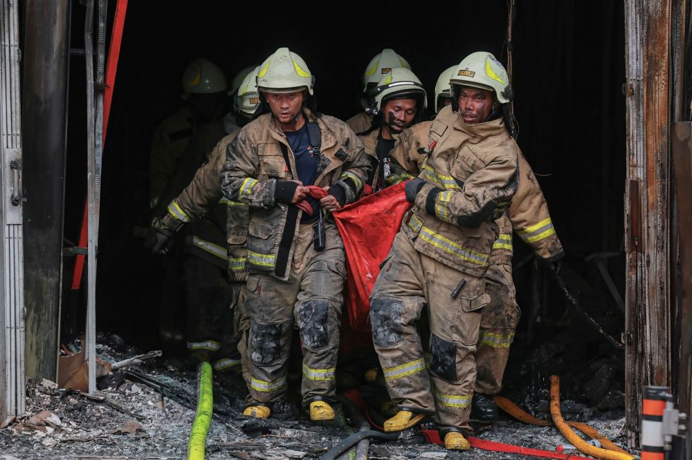 Firefighters move out the body of a victim from a seven-storey building in central Jakarta on December 9, 2025, after a fire that killed at least 20 people. — AFP pic Firefighters move out the body of a victim from a seven-storey building in central Jakarta on December 9, 2025, after a fire that killed at least 20 people. — AFP pic