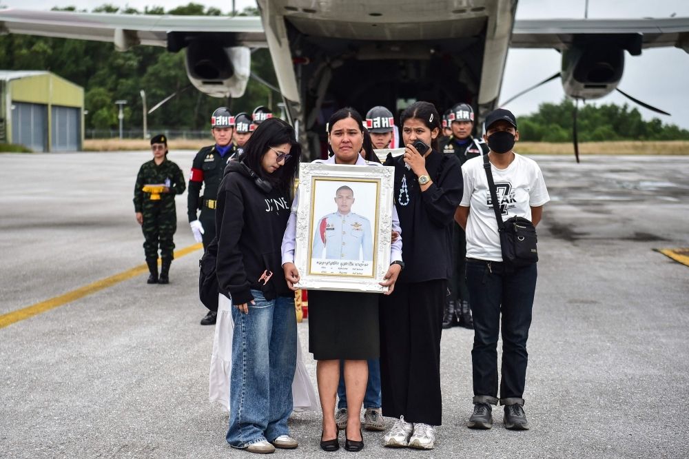 Thailand cuts fuel flow via Laos over fears of diversion to Cambodian troops; Asean foreign ministers’ meet pushed to Dec 22 The mother and relatives of Special Forces volunteer Mustakim Majehma, who died in Cambodia–Thailand border clashes, carry his portrait during a military ceremony at Narathiwat airport, Thailand, on December 14, 2025. — AFP pic