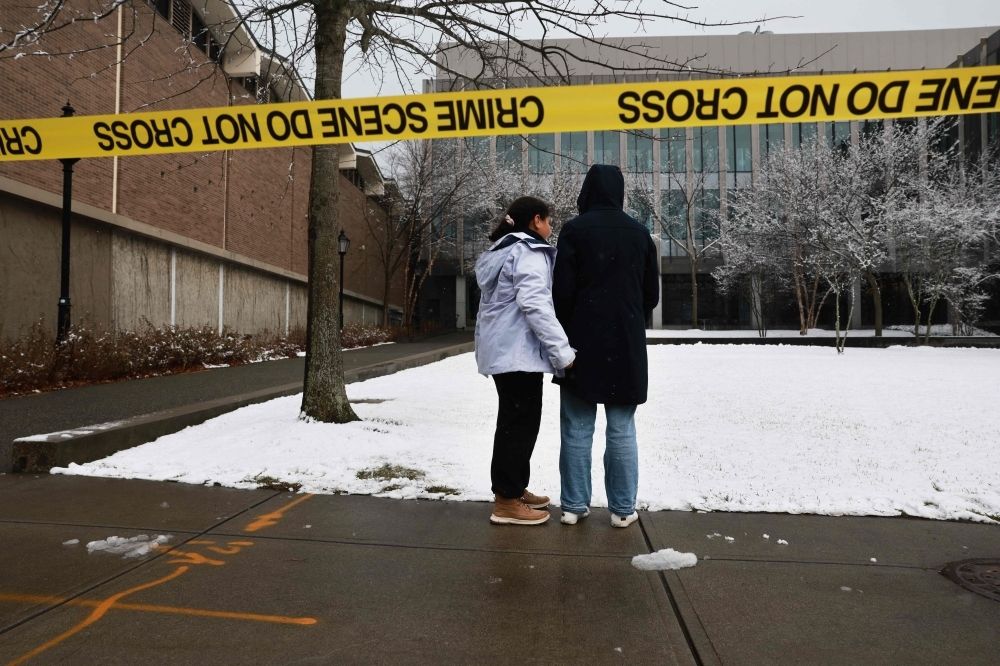 Wrong guy: US police release ‘person of interest’ in Brown University shooting during exams; gunman still at large People pause outside of the engineering and physics building at Brown University, the site of a mass shooting that left at least two people dead and nine others injured, on December 14, 2025 in Providence, Rhode Island. — Getty Images pic via AFP