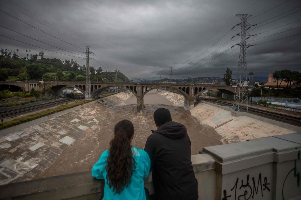 Christmas storm batters Southern California with floods, power outages, mudslide fears A couple watches the high water level of the Los Angeles river after heavy rains on December 24, 2025 in Los Angeles, California. A major winter storm rolled into California on December 23, forcing hundreds of evacuations in burn areas while threatening flooding and travel delays through Christmas for much of the state, officials said. — AFP pic