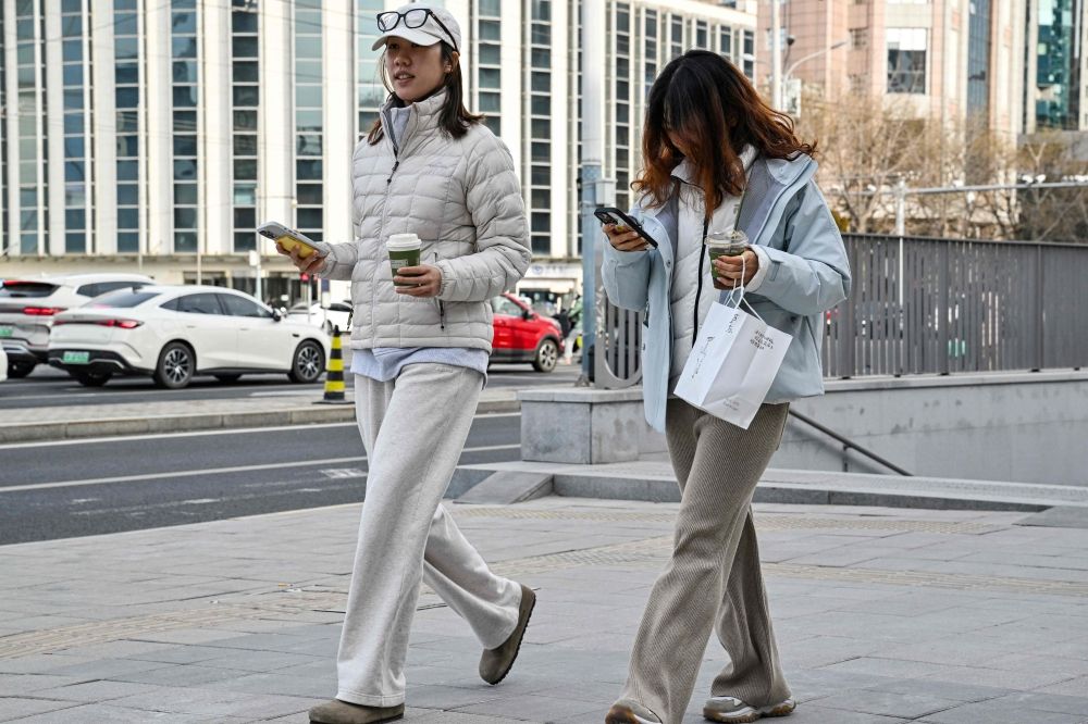 Two women walk along a street in Beijing on January 4, 2026. — AFP pic Two women walk along a street in Beijing on January 4, 2026. — AFP pic