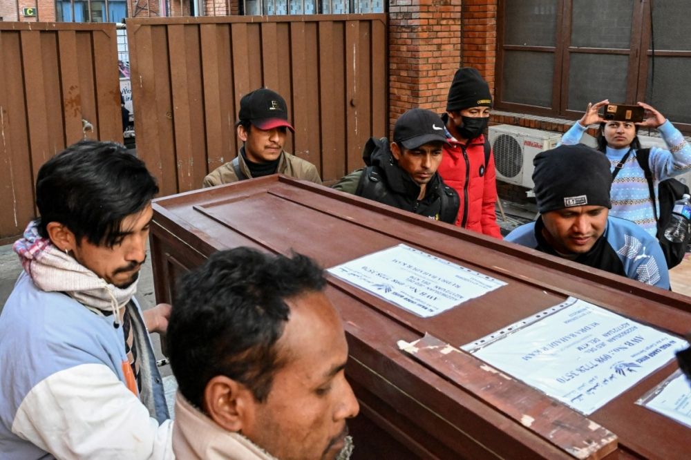 This photograph taken on January 21, 2026 shows Lalit Bishowkarma (back C), son of migrant worker Rudra Bahadur Kami, loading his father's coffin onto a truck upon its arrival at Tribhuvan International Airport in Kathmandu. — AFP pic This photograph taken on January 21, 2026 shows Lalit Bishowkarma (back C), son of migrant worker Rudra Bahadur Kami, loading his father's coffin onto a truck upon its arrival at Tribhuvan International Airport in Kathmandu. — AFP pic