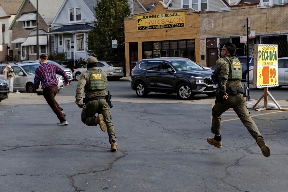 Federal agents chase a man through a parking lot in the Avondale neighborhood following a confrontation during immigration raids, after US President Donald Trump ordered increased federal law enforcement presence to assist in crime prevention, in Chicago, Illinois October 25, 2025. — Reuters pic Federal agents chase a man through a parking lot in the Avondale neighborhood following a confrontation during immigration raids, after US President Donald Trump ordered increased federal law enforcement presence to assist in crime prevention, in Chicago, Illinois October 25, 2025. — Reuters pic