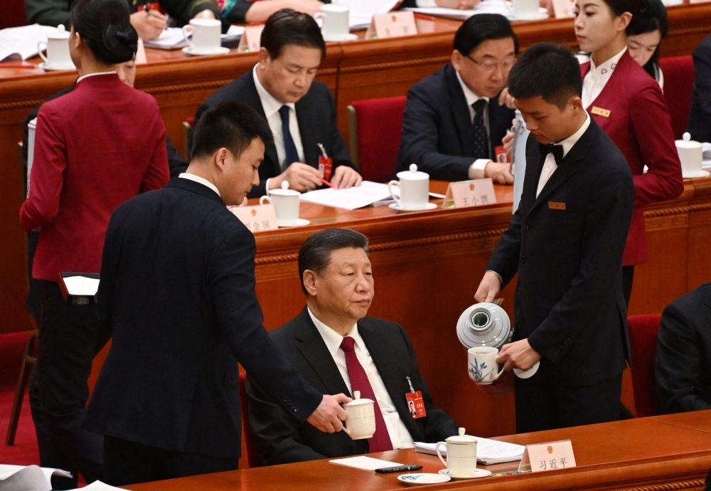 Workers replenish Chinese President Xi Jinping’s teacups during the opening session of the National People’s Congress at the Great Hall of the People in Beijing on March 5, 2024. — AFP pic Workers replenish Chinese President Xi Jinping’s teacups during the opening session of the National People’s Congress at the Great Hall of the People in Beijing on March 5, 2024. — AFP pic