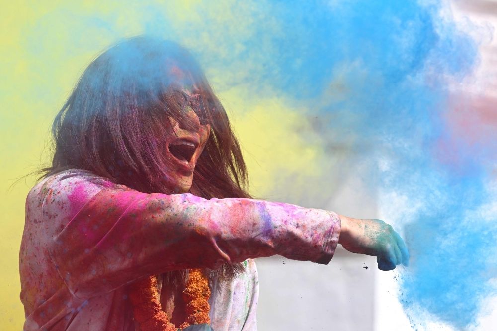 A woman smeared with coloured powder celebrates Holi, the Hindu spring festival of colours, at Durbar Square in Kathmandu on March 2, 2026. — AFP pic