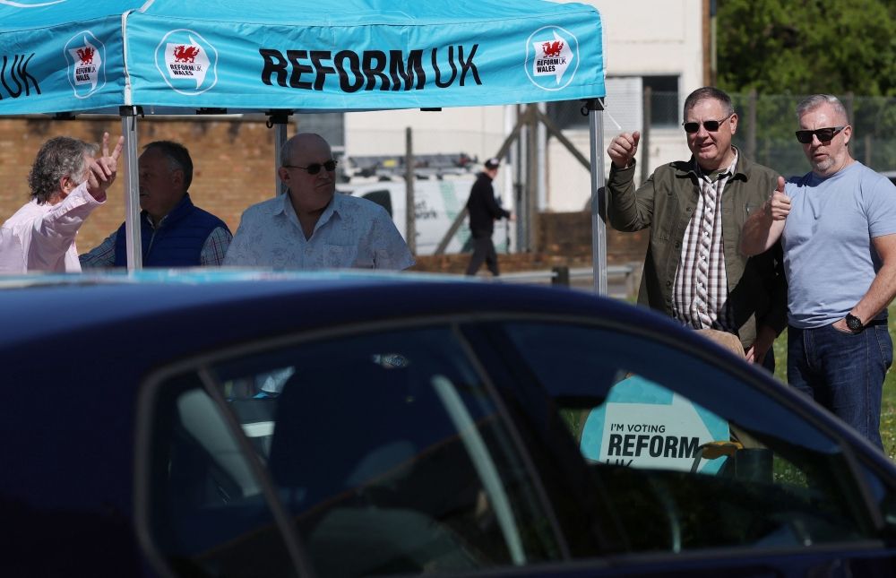 In Wales, UK Labour Party loses grip on storied heartland Reform UK members gesture towards hooting drivers during campaigning for the Senedd election in Merthyr Tydfil, South Wales on April 24, 2026. Wales -- the cradle of Britain's revered National Health Service and a former industrial powerhouse -- has been a Labour Party stronghold for well over a century. But that is set to end in crunch polls next week as impatient Britons abandon their old political loyalties for anti-establishment parties amid persistent cost of living pressures. — AFP pic