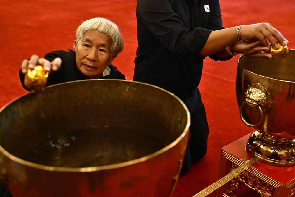 A member of the public dips a cup while paying respects in front of a portrait of the late Thai Princess Bajrakitiyabha Mahidol in the royal throne hall at the Grand Palace in Bangkok on June 13, 2026. — AFP pic A member of the public dips a cup while paying respects in front of a portrait of the late Thai Princess Bajrakitiyabha Mahidol in the royal throne hall at the Grand Palace in Bangkok on June 13, 2026. — AFP pic
