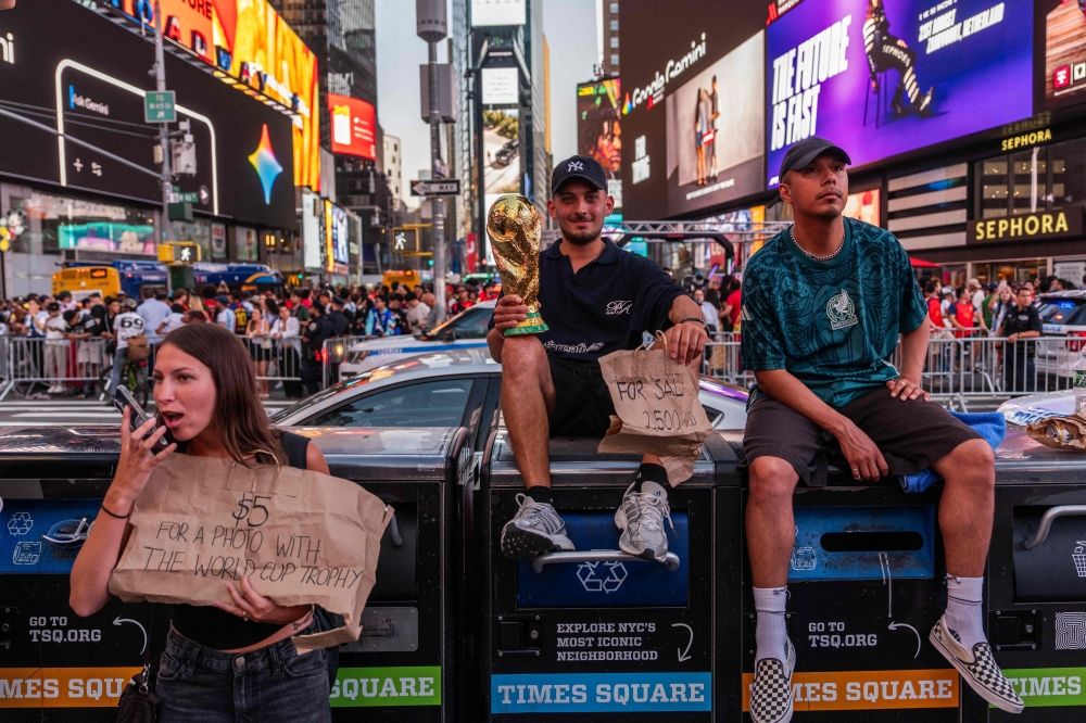 A tout holds a replica trophy for sale as people gather in Times Square after Spain defeated Argentina in the 2026 World Cup final. — Getty Images via AFP A tout holds a replica trophy for sale as people gather in Times Square after Spain defeated Argentina in the 2026 World Cup final. — Getty Images via AFP