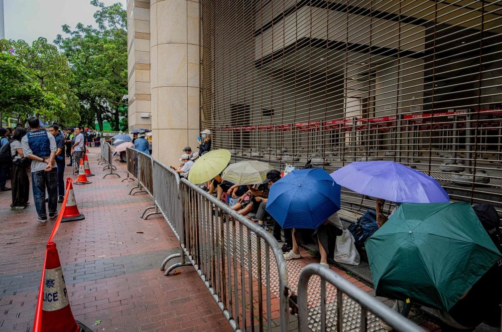 People wait under umbrellas outside the West Kowloon Magistrates’ Courts ahead of the verdict in the national security trial of two pro-democracy Tiananmen activists, in Hong Kong August 21, 2026. — AFP pic People wait under umbrellas outside the West Kowloon Magistrates’ Courts ahead of the verdict in the national security trial of two pro-democracy Tiananmen activists, in Hong Kong August 21, 2026. — AFP pic