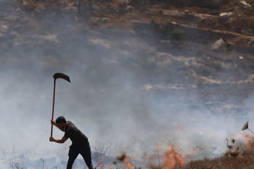 A local Palestinian farmer tries to extinguish fires on land after Israel’s army soldiers fired tear gas as they harvested their olives, resulting in the dry fields catching fire, in the village of Asira al-Qibliya, south of the Israeli-occupied city of Nablus, on October 3, 2026. — AFP pic A local Palestinian farmer tries to extinguish fires on land after Israel’s army soldiers fired tear gas as they harvested their olives, resulting in the dry fields catching fire, in the village of Asira al-Qibliya, south of the Israeli-occupied city of Nablus, on October 3, 2026. — AFP pic