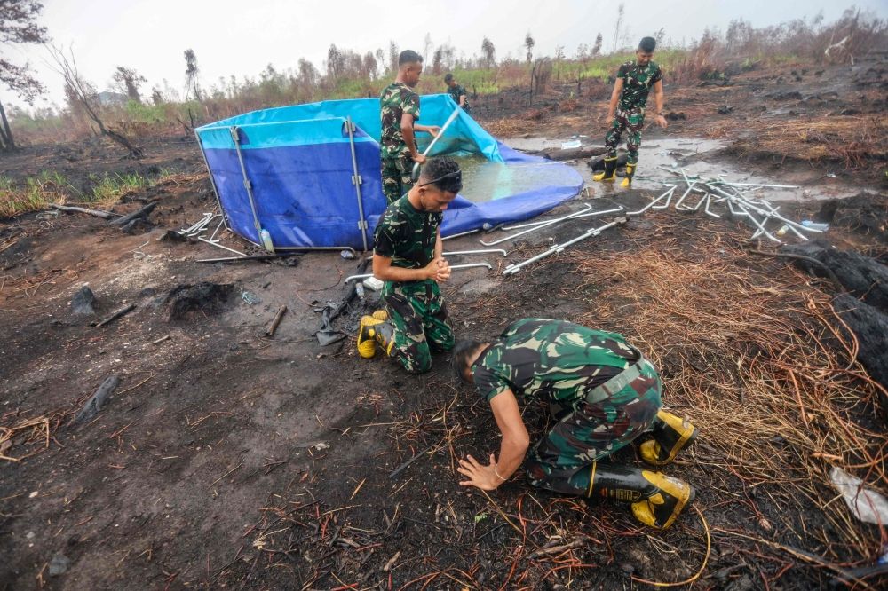 Firefighters kiss the ground as rain falls on Indonesia’s haze-hit city Palangkaraya, but dry spell may return Indonesian soldiers, tasked with fighting forest and land fires, celebrate as it rains in Banjar Baru, South Kalimantan province on October 28, 2026, following months of forest and land fires. — AFP pic