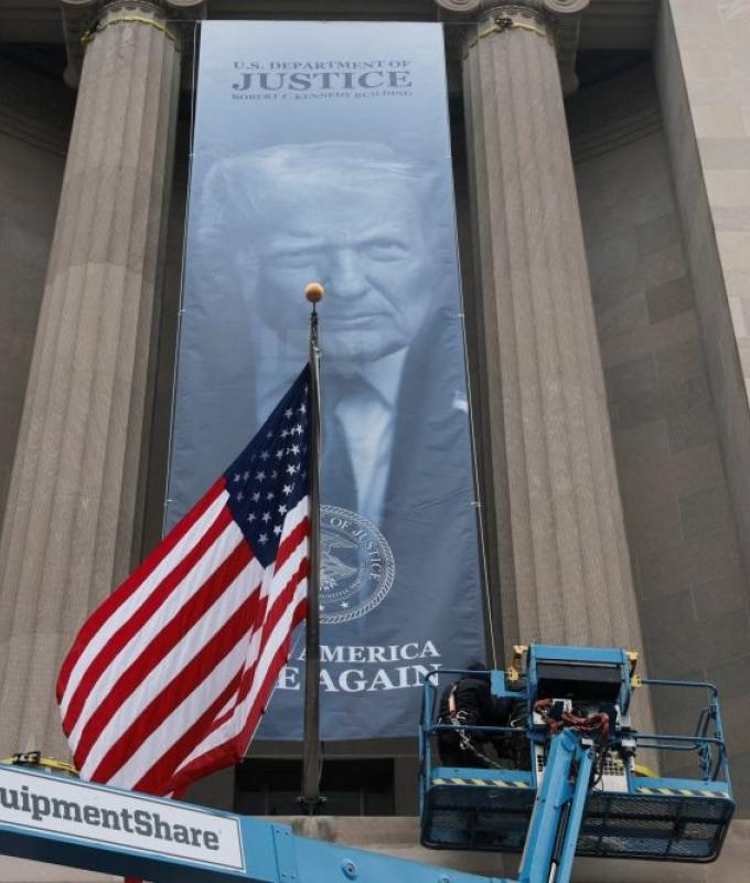 Trump’s image unfurled outside US Justice Dept headquarters in latest imprint move