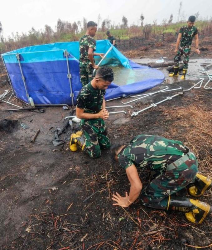 Firefighters kiss the ground as rain falls on Indonesia’s haze-hit city Palangkaraya, but dry spell may return