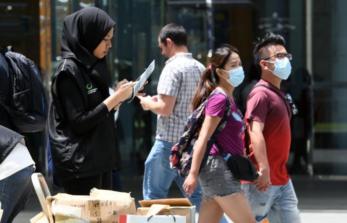 Singapore raises virus alert level as new cases show infection spread
