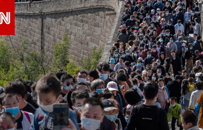 Crowds of tourists sweep the Great Wall of China amid the...