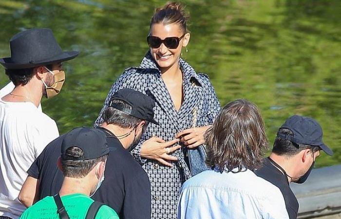 Bella Hadid shows sculpted legs in a chic 1950s wrap coat...