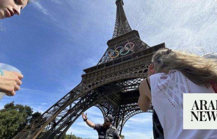 A man is seen climbing the Eiffel Tower, prompting an evacuation hours before closing ceremony