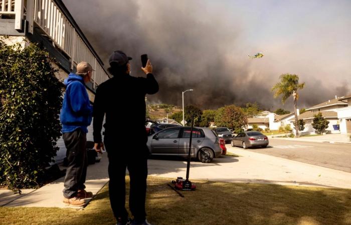 Thousands flee as hurricane-force winds drive ‘dangerously fast’ wildfire through Los Angeles suburbs