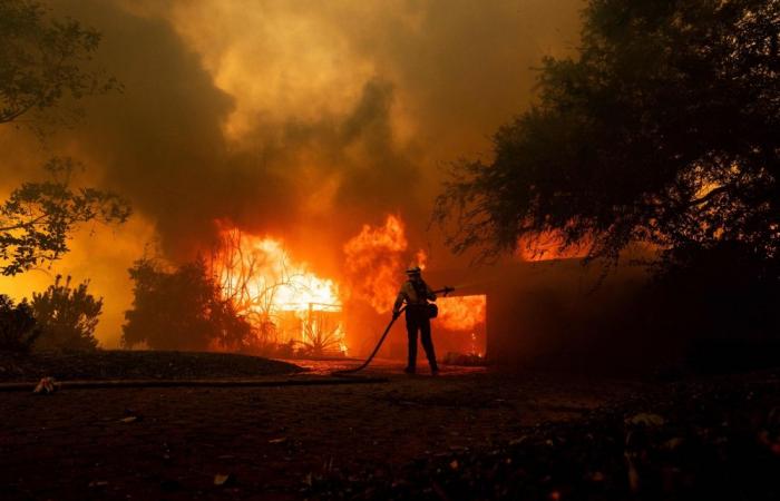 Thousands flee as hurricane-force winds drive ‘dangerously fast’ wildfire through Los Angeles suburbs